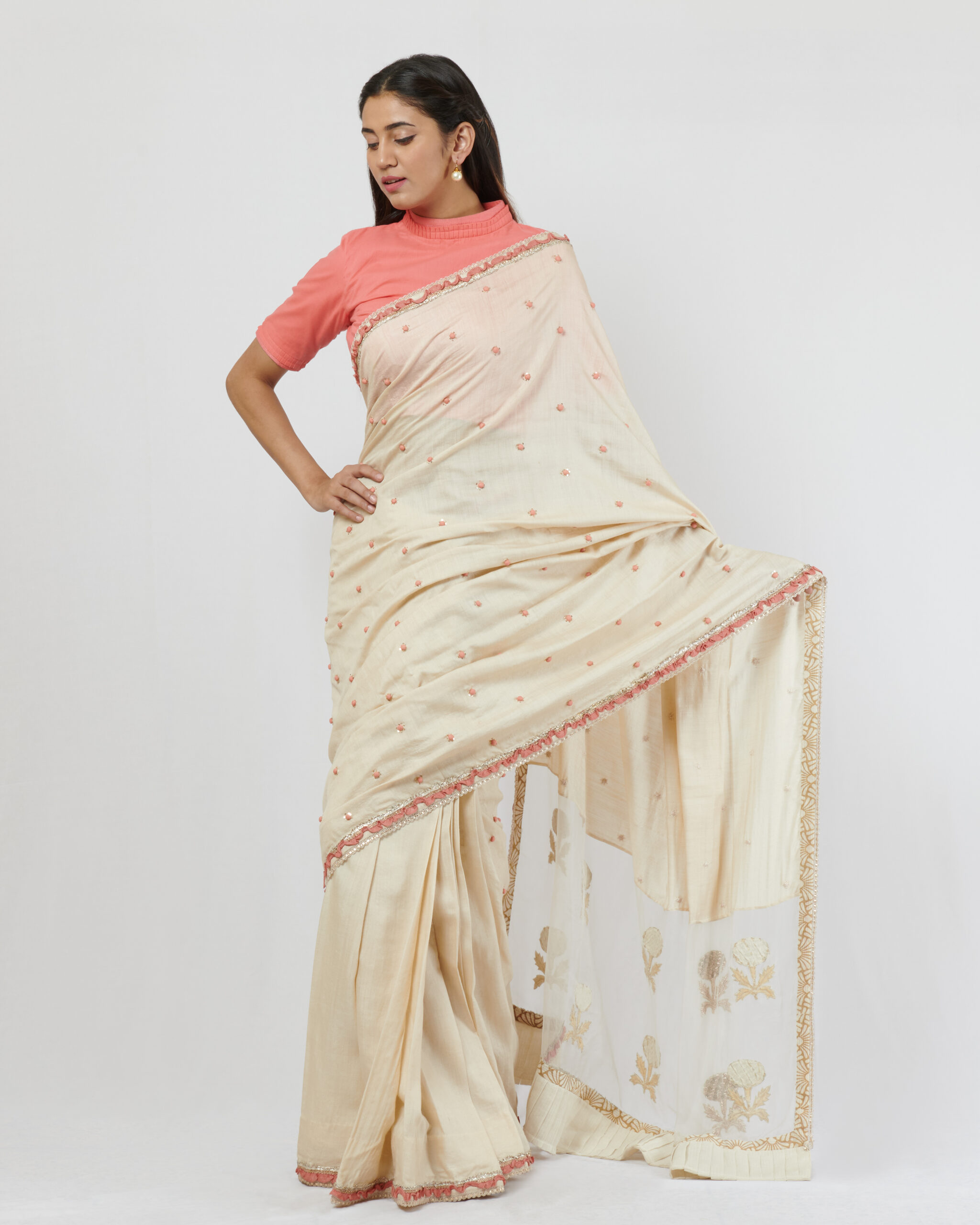 Soft tussar silk sari with multiple fine borders and peach hand crafted potlis all over in the second half of the sari with an organza pallu