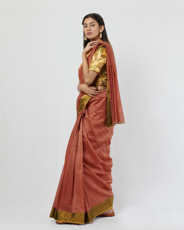 Rust zari chex chanderi sari with green tissue border at the skirt and gold zardozi detail at the shoulder and pallu