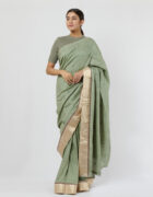 Sage green soft tussar sari with loops detail at the shoulder and pallu and a gold silk tissue border at the skirt adorned with hand embroidered butis all over