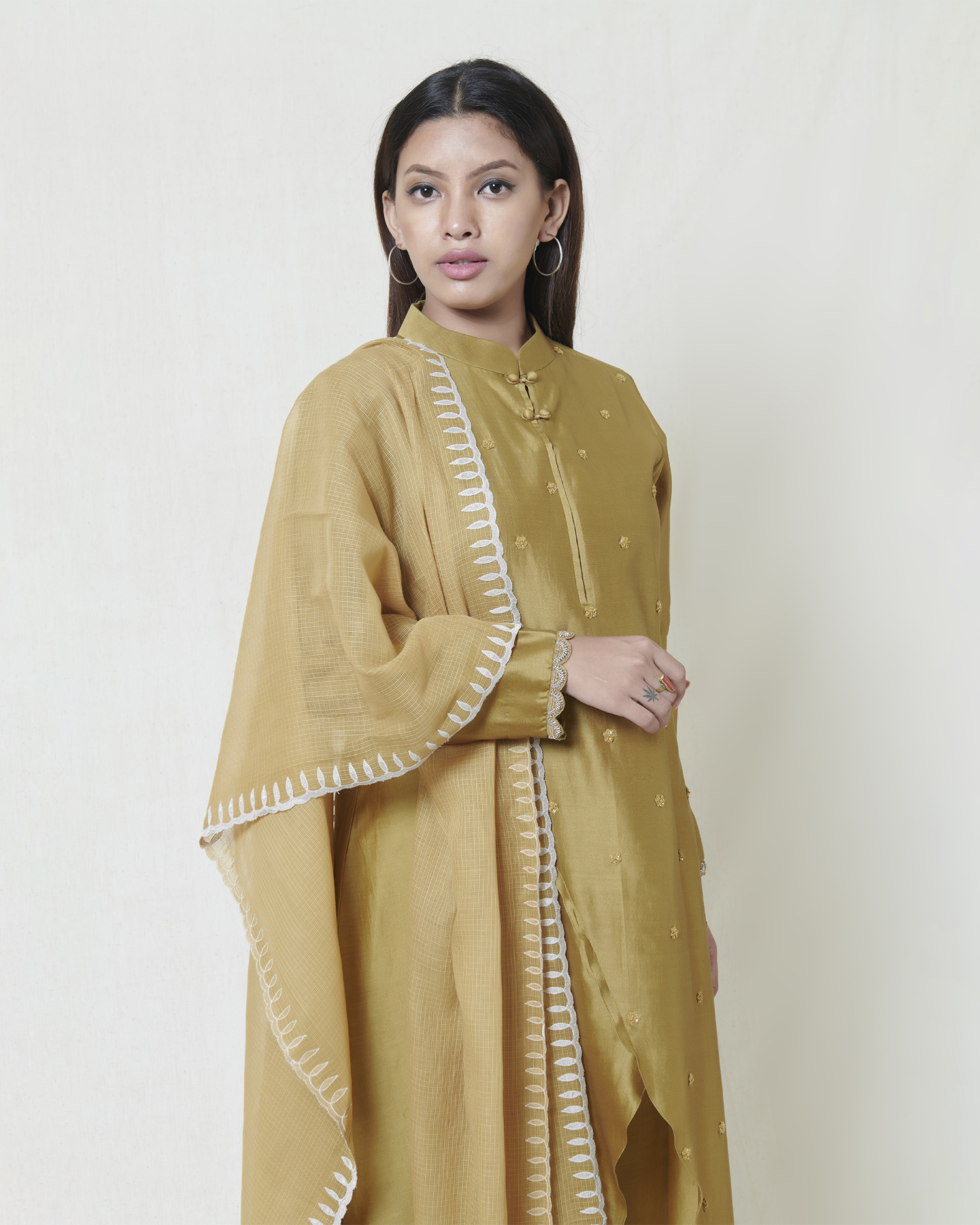 Light olive chanderi kurta with hand embroidery butis and zardozi cuffs complemented with silver kanchi tissue applique and cutwork detail kota dupatta.