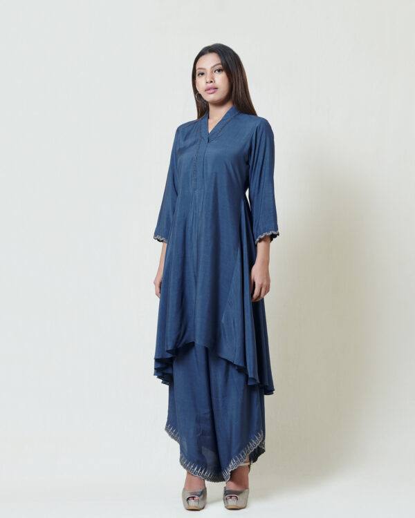 Indigo blue highlow tunic with hand thread embroidery detail at neckline paired with grey kanchi tissue applique and cut work detailed drape pants.