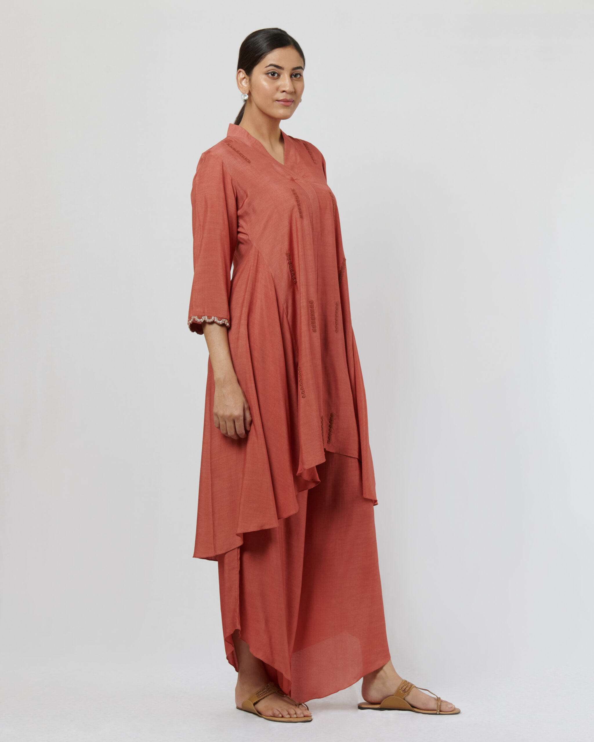 Rust high low tunic with hand thread embroidery detail paired with drape pants