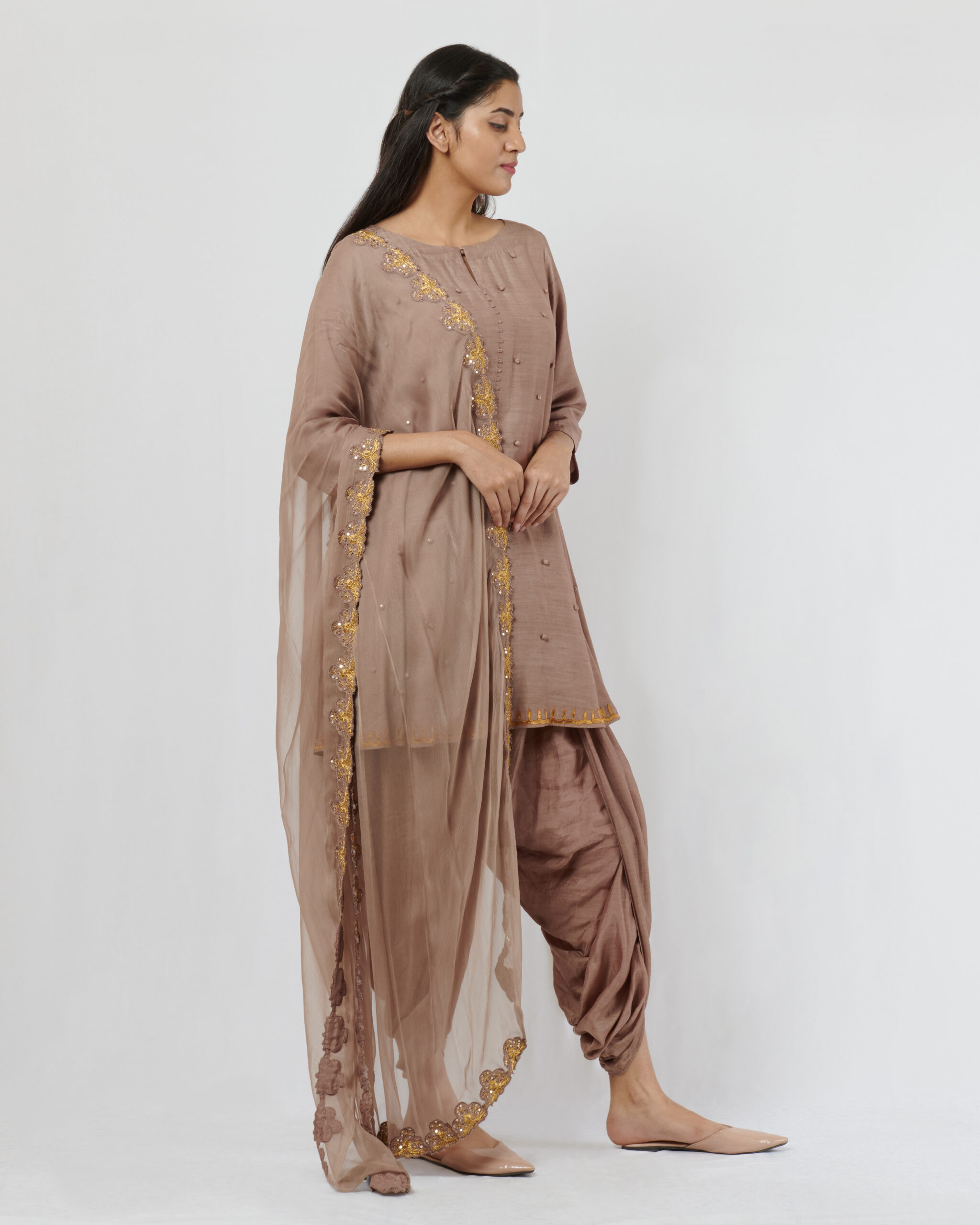 Spun silk kurta with hand crafted potlis and sequence details teamed with a chiffon gold aari hand embroidered dupatta. It comes along with dhoti pants