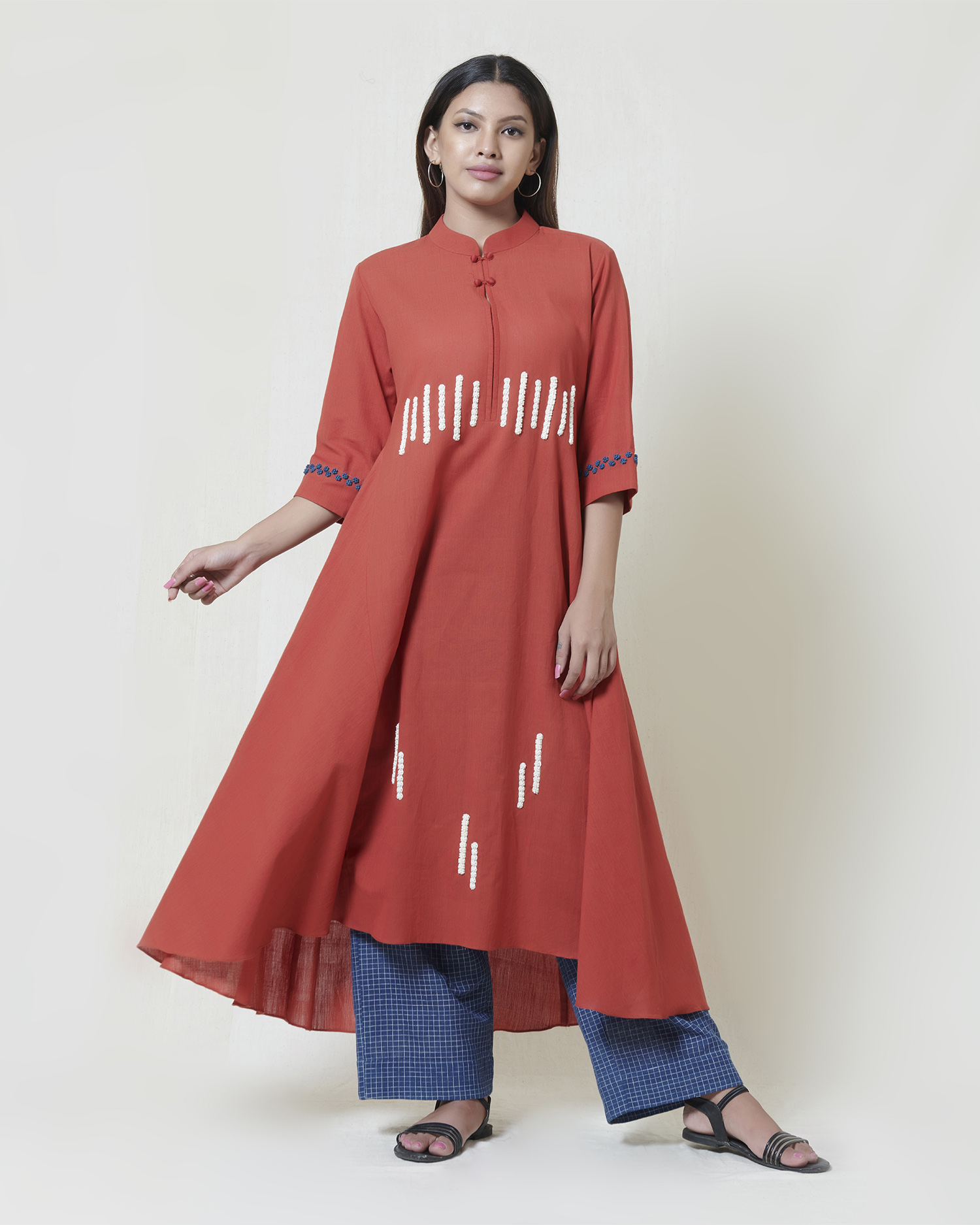 Chilli red high low kurta in khadi with ivory and indigo thread hand embroidery detailing
