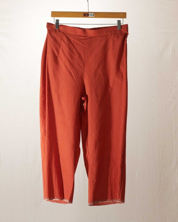 Rust pant with dull gold kanchi tissue applique hemline